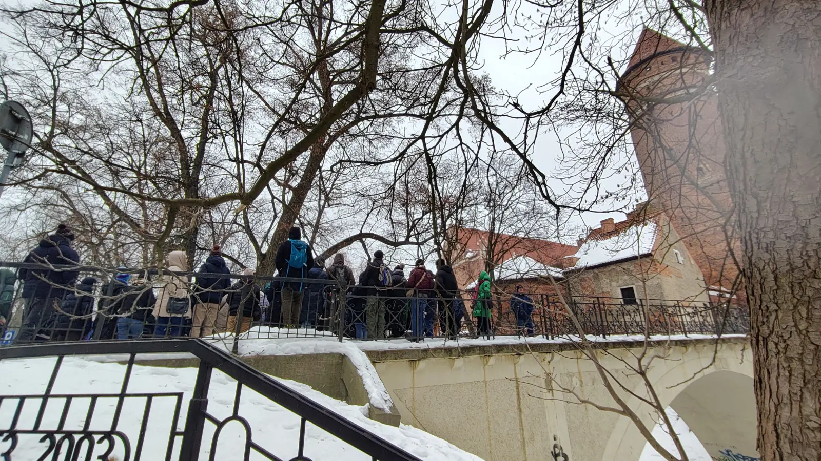 Turyści słuchający opowieści o kryminalnym obliczu Olsztyna pod zamkiem